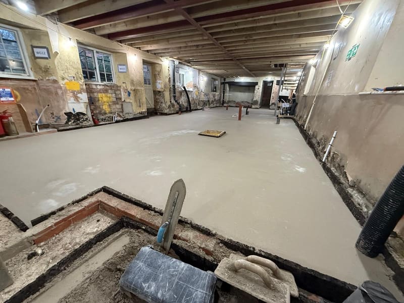 Freshly floated limecrete slab across a large interior