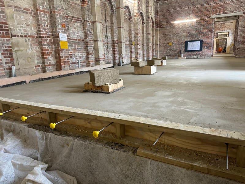 Limecrete slab curing in a heritage brick hall